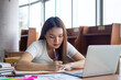 © Shisu_ka - Asian female students are sitting reading books in the university library. Students prepare exams and report or study online through a computer.