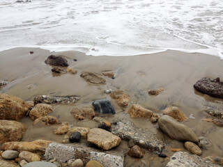 Beach surf coastline sand foam rocks stone