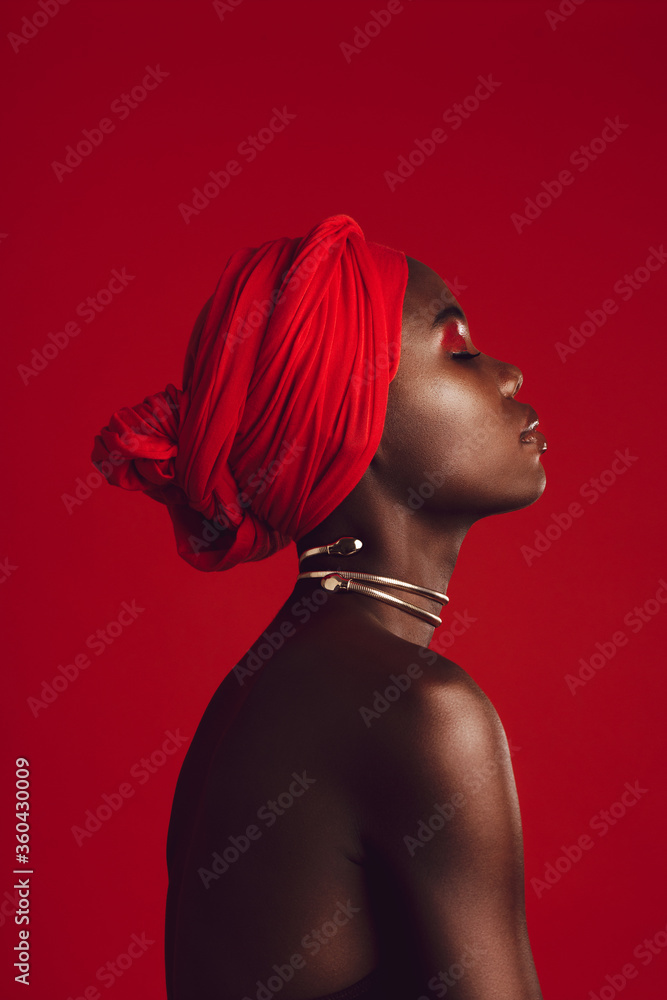 Profile view of attractive woman wearing a red turban - obrazy, fototapety, plakaty 
