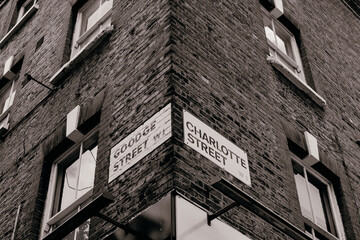 London, UK - 14 June, 2020;
Goodge street name sign on the building, low angle view, and BT tower is on the side background.