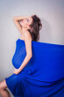 Sexy and Fit 8 Months Pregnant Woman Covered in Blue Tulle, from Profile, on Grey Background. Boudoir Shoot