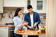 © Prostock-studio - Happy couple preparing salad together at home