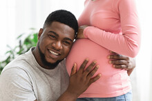 Closeup Of Man Listening His Happy Pregnant Wife Belly