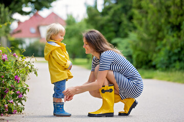 Poster - Mother and toddler child, boy, playing in the rain