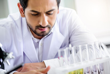 Wall Mural - caucasian scientist man lab technical service observe liquid sample with lab glassware and test tube