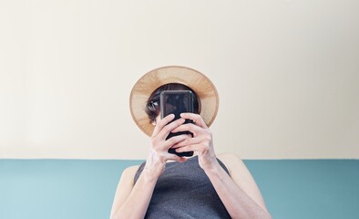 Sticker - Low angle shot of a Caucasian young female wearing a hat texting on the phone