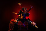 Fototapeta Sawanna - Portrait of a samurai in red armor in profile, his katana on his shoulder