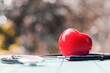 red heart and stethoscope on table
