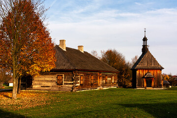 Wall Mural - Old traditional polish wooden church in an open-air museum of Kielce (Muzeum Wsi Kieleckiej), Tokarnia, Poland, Europe. Picture taken during famous polish golden autumn.