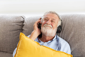 Wall Mural - Senior retirement man listen to music using headphone feeling happy in his home