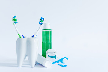 Oral hygiene products and model of tooth on white background.