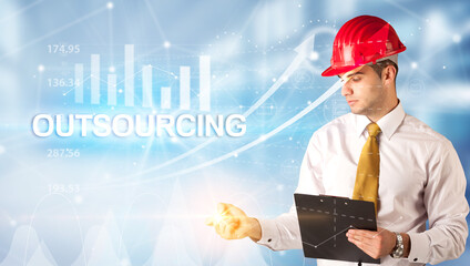 Young businessman with helmet drawing OUTSOURCING inscription, modern business technology concept