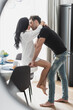© LIGHTFIELD STUDIOS - Side view of handsome man kissing sensual girlfriend during breakfast in kitchen