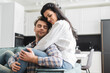 © LIGHTFIELD STUDIOS - Beautiful woman hugging handsome man on couch in living room
