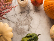Autumn Harvest Moody Frame Background With Different Pumpkins, Fall Fruit And Flowers On Marble Table. Flat Lay