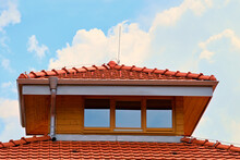 Exterior Detail Of New Wooden House Attic With Red Roof Tiles And Aluminium Gutters