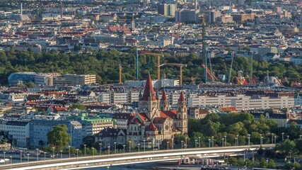 Poster - Aerial panoramic view of Vienna city with Church of St. Francis of Assisi, historic buildings and a riverside promenade timelapse in Austria. Evening skyline before sunset from Danube Tower viewpoint