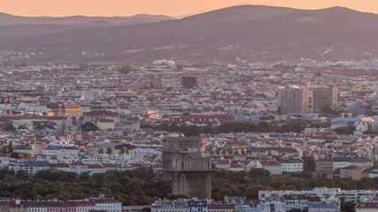 Poster - Aerial panoramic view of Vienna city with skyscrapers, historic buildings and mountains on a background timelapse in Austria. Evening skyline before sunset from Danube Tower viewpoint