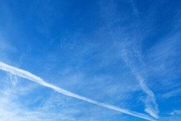 Wall Mural - Blue sky with airline crossing it on left side