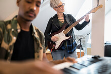 Woman Playing Guitar In Music Studio
