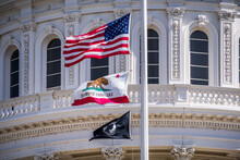 The US Flag, The California Flag And The POW-MIA Flag Waving In The Wind In Front Of The Capitol State Building In Downtown Sacramento