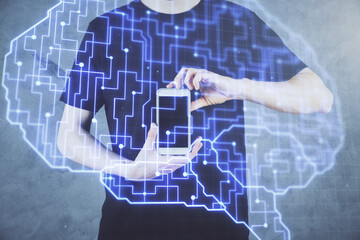 Double exposure of man's hand holding and using a digital device and brain hologram drawing. Data concept.