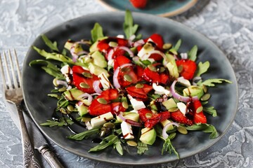 Poster - salad with strawberries and avocado, arugula, feta cheese, pumpkin seeds, red onion. dressed with balsamic sauce