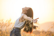 free happy woman enjoying sunset. Beautiful woman in white dress embracing the golden sunshine glow of sunset with arms outspread and face raised in sky enjoying peace, serenity in nature