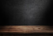 © Elena - Empty wooden table on abstract black wall in dark room background 3d illustration.