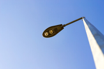 Street lamp against the blue sky. View from below. Architecture.