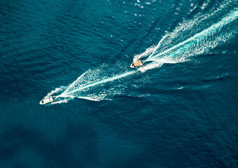 Two motor boats speeding on ocean, aerial top down view