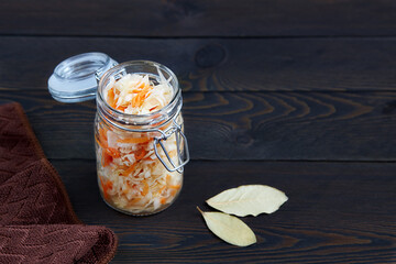 Wall Mural - Fermented cabbage in jar on a dark wooden background. Homemade sauerkraut.