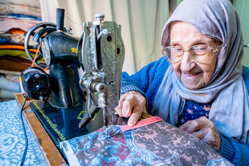 Wall Mural - Arabic muslim woman sewing and measuring lengths with her tape