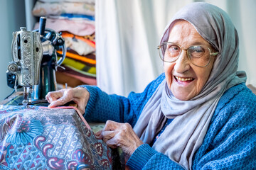 Wall Mural - Arabic muslim woman sewing and measuring lengths with her tape