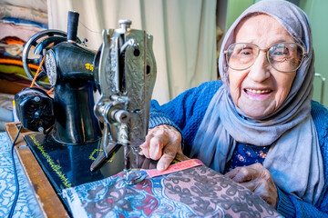 Wall Mural - Arabic muslim woman sewing and measuring lengths with her tape