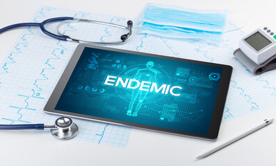 Tablet pc and doctor tools with ENDEMIC inscription, coronavirus concept