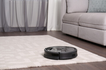 Canvas Print - Hoovering floor with modern robotic vacuum cleaner in living room