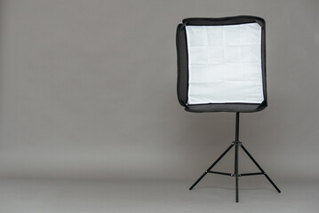 Studio softbox on a tripod on a gray background with copy space.