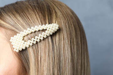 Young woman with beautiful hair clip on blue background, closeup