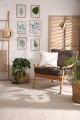 Wall Mural - Stylish room interior with different artworks and armchair