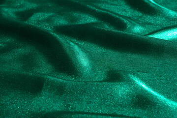 Wall Mural - Wavy texture of green silk fabric. Colorful background with expensive holiday canvas.