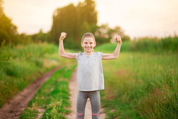 Wall Mural - Child cute girl show biceps gesture of power and strength outdoor. Feel so powerful. Girls rules concept.