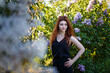 © elenaseiryk - Portrait of young woman or girl among lilac blooming bushes