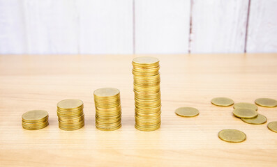 Stack of coins stacked on a wooden table.