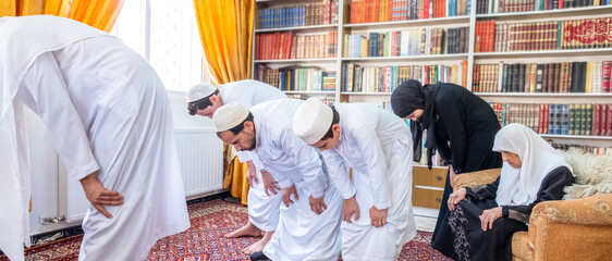 Wall Mural - Muslim family praying together and doing bowing