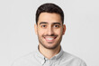 © Damir Khabirov - Headshot portrait of young smiling handsome man wearing gray shirt, isolated on studio background