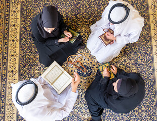 Top view of muslim family members reading quraan together