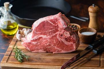 fresh thick cut  T-bone steak on wooden cutting board