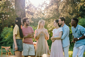 Wall Mural - Company of three happy young couples discussing news or their plans for summer