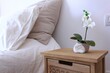 Closeup shot of a wooden nightstand with a small plant in a pot and a good night text in Spanish